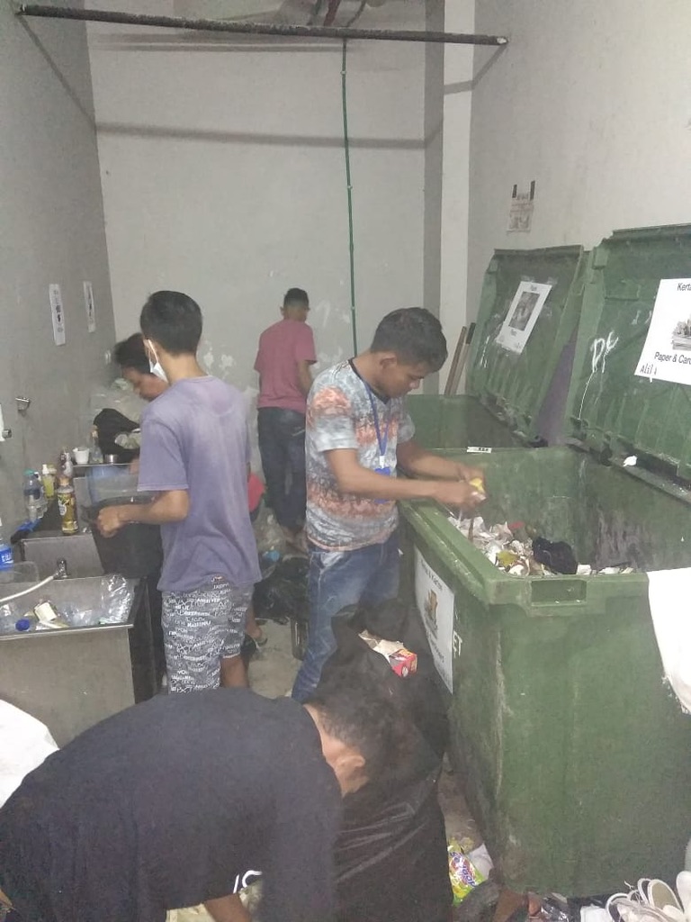 Image 15. Team sorting materials into large green bins indoors