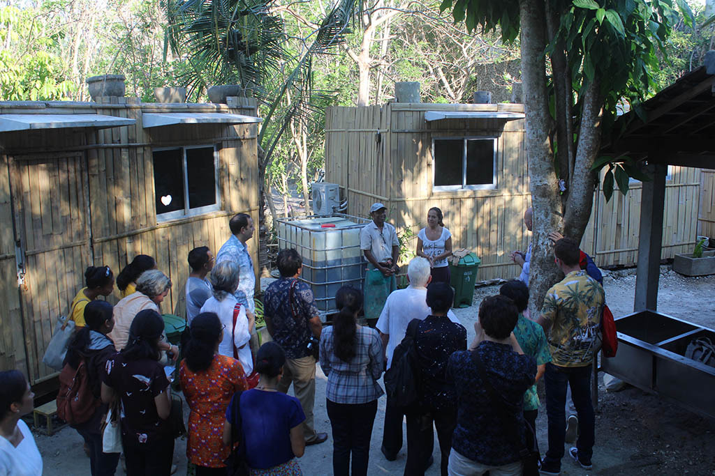 Image 1. Visitors listening during a tour of bamboo recovery facilities