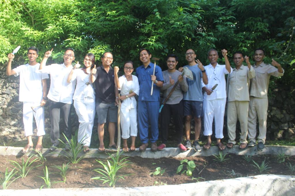 Image 4. Group of people with garden tools along a planted bed