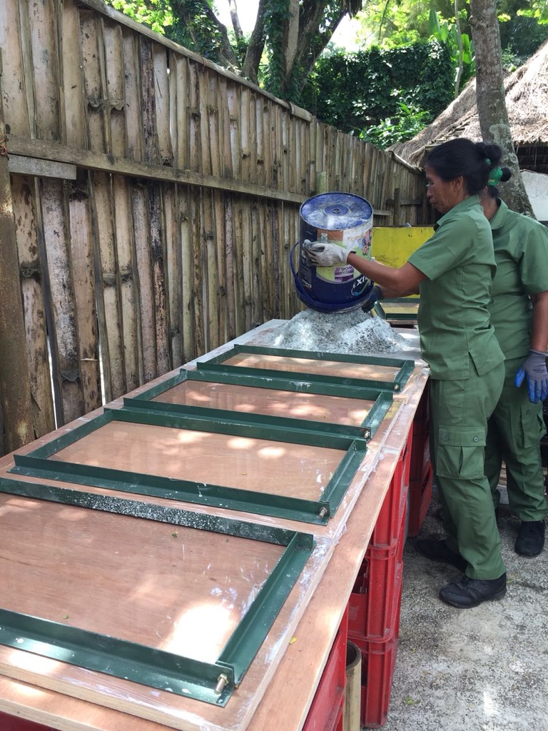 Image 28. Workers pouring aggregate mix into tile mould frames