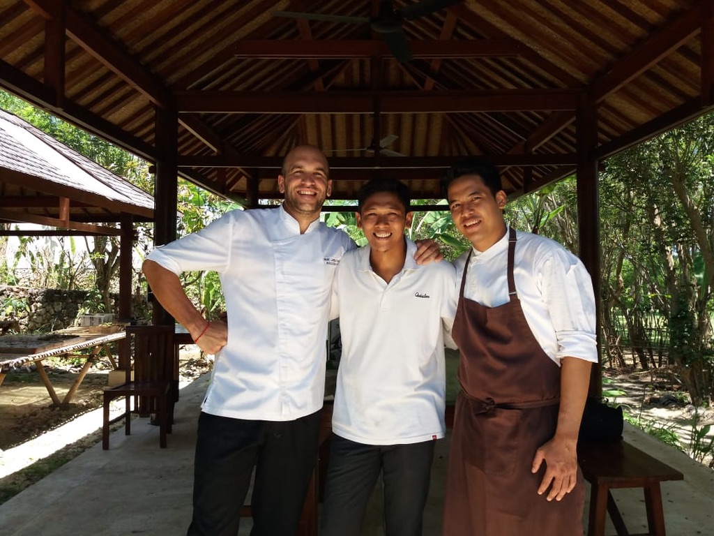 Image 3. Three kitchen and hotel team members under an open pavilion