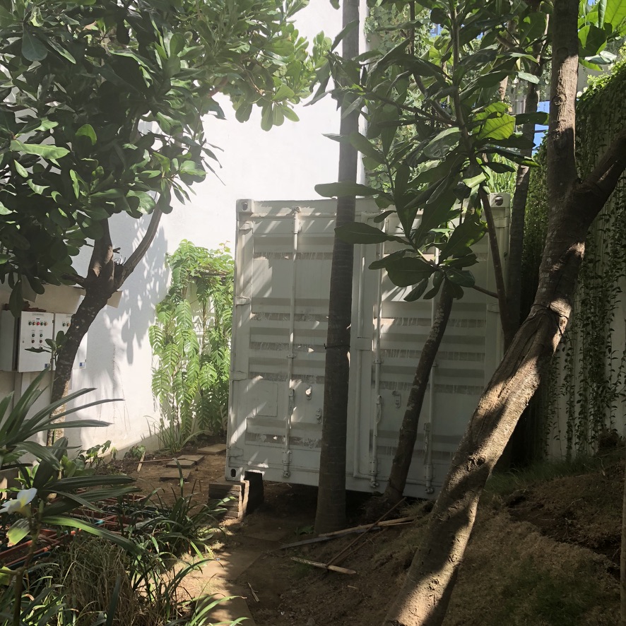 Image 34. White shipping container among trees on a property